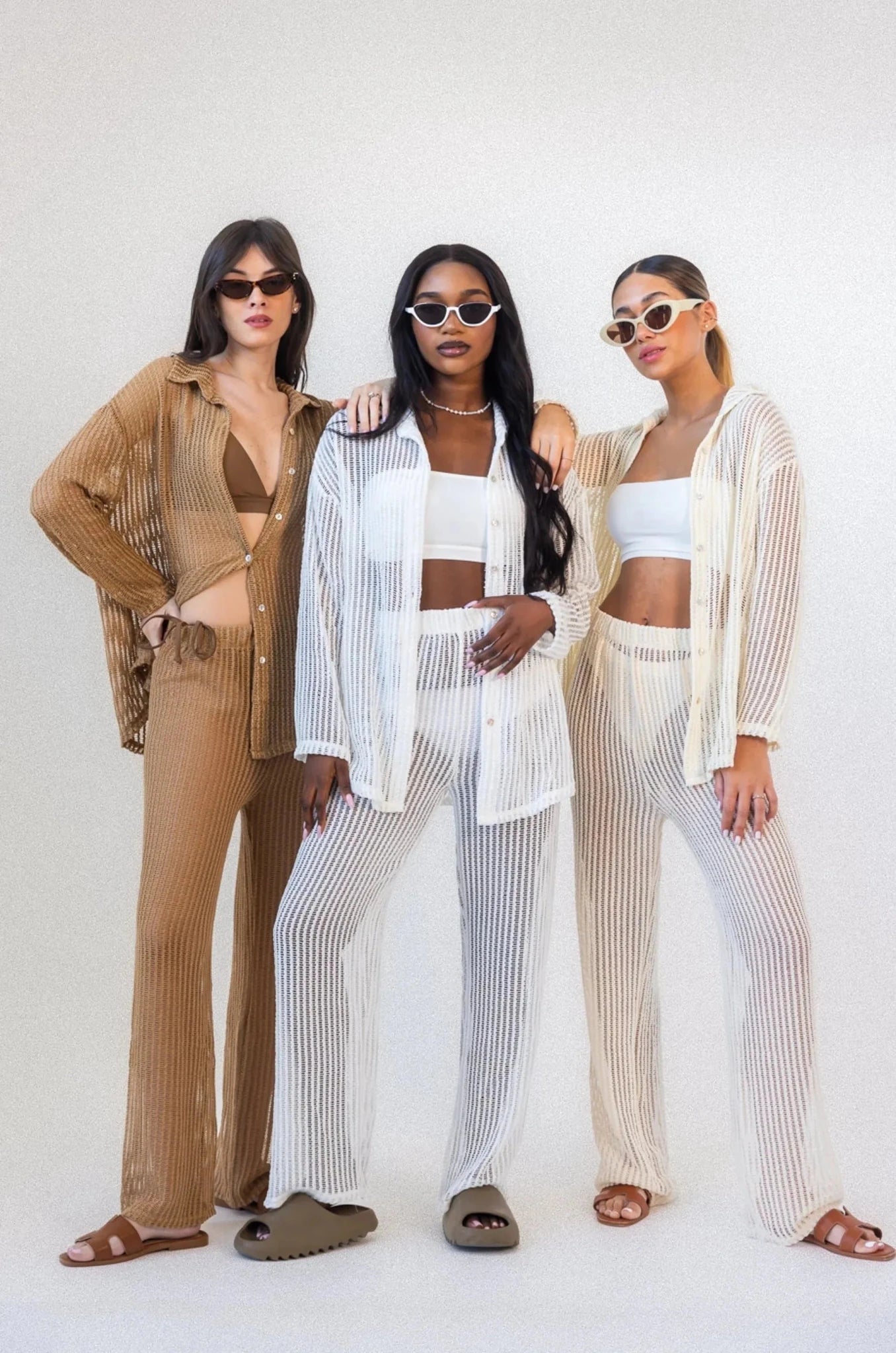 שלוש נשים עם משקפי שמש לובשות חליפות קיץ רשת טרנדיות בצבעים ניוד ולבן