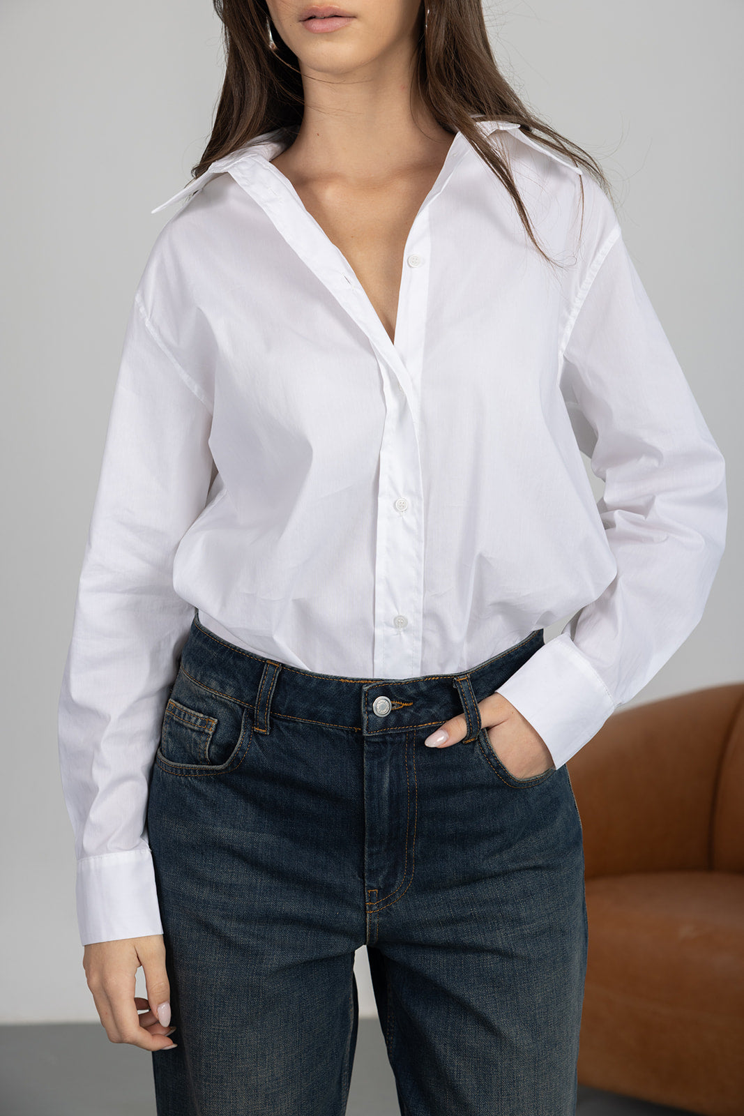 חולצה לבנה מכופתרת לנשים עם ג'ינס כהה, אופנת נשים מודרנית, צילום בסטודיו