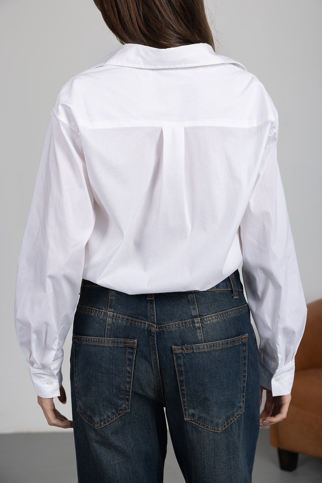 חולצה לבנה ארוכה עם כפתורים לנשים בשילוב ג'ינס בגזרה גבוהה, מראה קז'ואל אופנתי