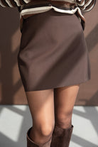 חצאית מיני חומה לנשים, בד חלק, עם סוודר פסים ומגפיים חומים בגזרה צעירה ואופנתית