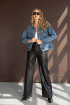 אישה עם ז'קט ג'ינס, מכנסי עור שחורים ומשקפי שמש, אופנת נשים צעירות