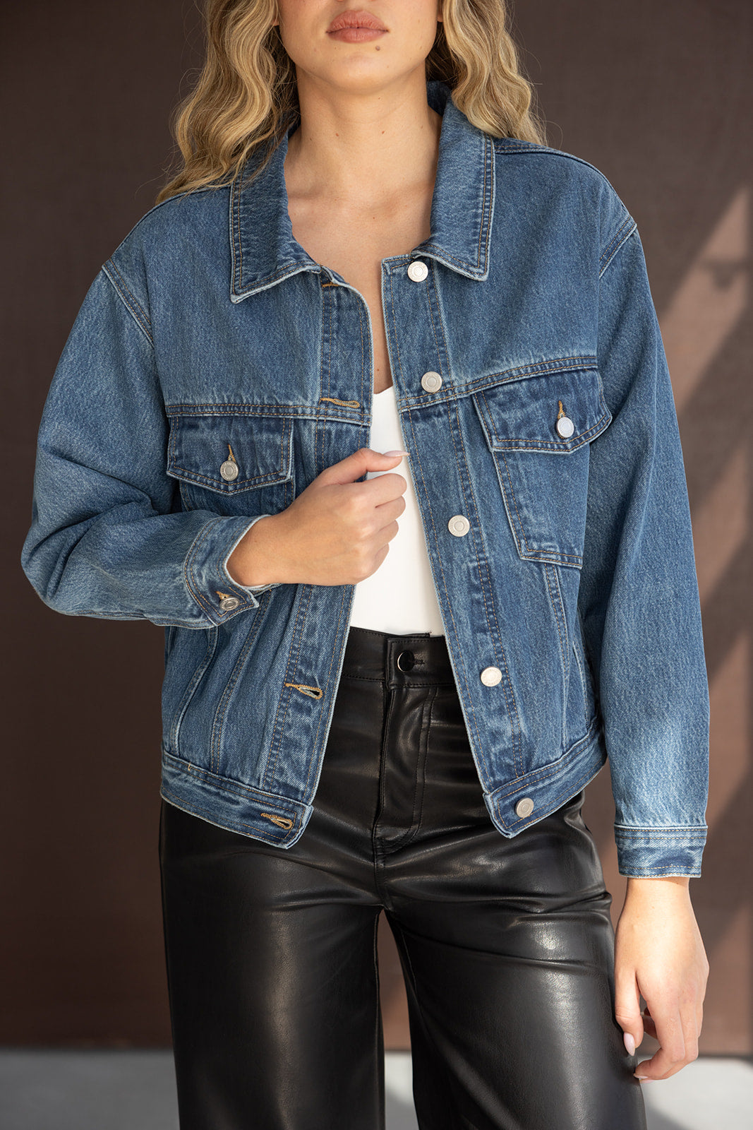 ג'קט ג'ינס לנשים עם כפתורים, משולב עם מכנסי דמוי עור שחורים, אופנת נשים ישראלית