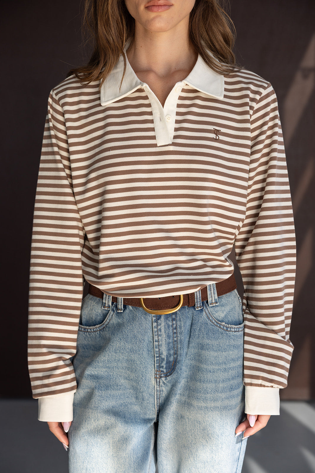 חולצת פסים חומה ולבנה עם שרוולים ארוכים וצווארון, משולבת עם ג'ינס כחול רחב, אופנת נשים