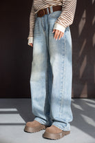 מכנסי ג'ינס בגזרה רחבה עם חגורה חומה, חולצה פסים ונעלי פלטפורמה חומות לנשים