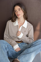 אישה לובשת חולצת פסים חומה ולבנה עם צווארון לבן ומכנסי ג'ינס רחבים, לוק אופנתי לנשים צעירות