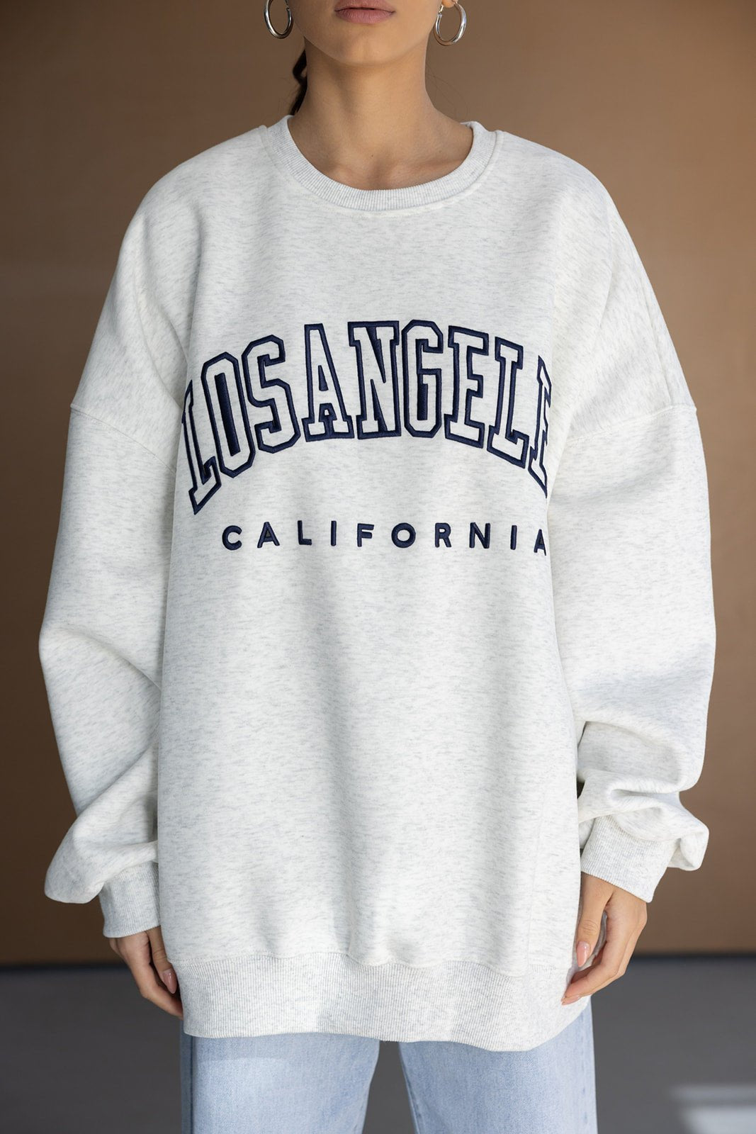 אישה לובשת סווטשירט אפור עם הדפס LOS ANGELES CALIFORNIA, אופנה לנשים, בגדי חורף