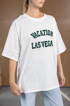 חולצת טי שירט לבנה לנשים עם כיתוב ירוק "VACATION LAS VEGAS", מראה קז'ואל אופנתי