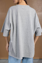 חולצת טי שירט אפורה לנשים בגזרה רחבה עם שרוולים קצרים, על רקע חום