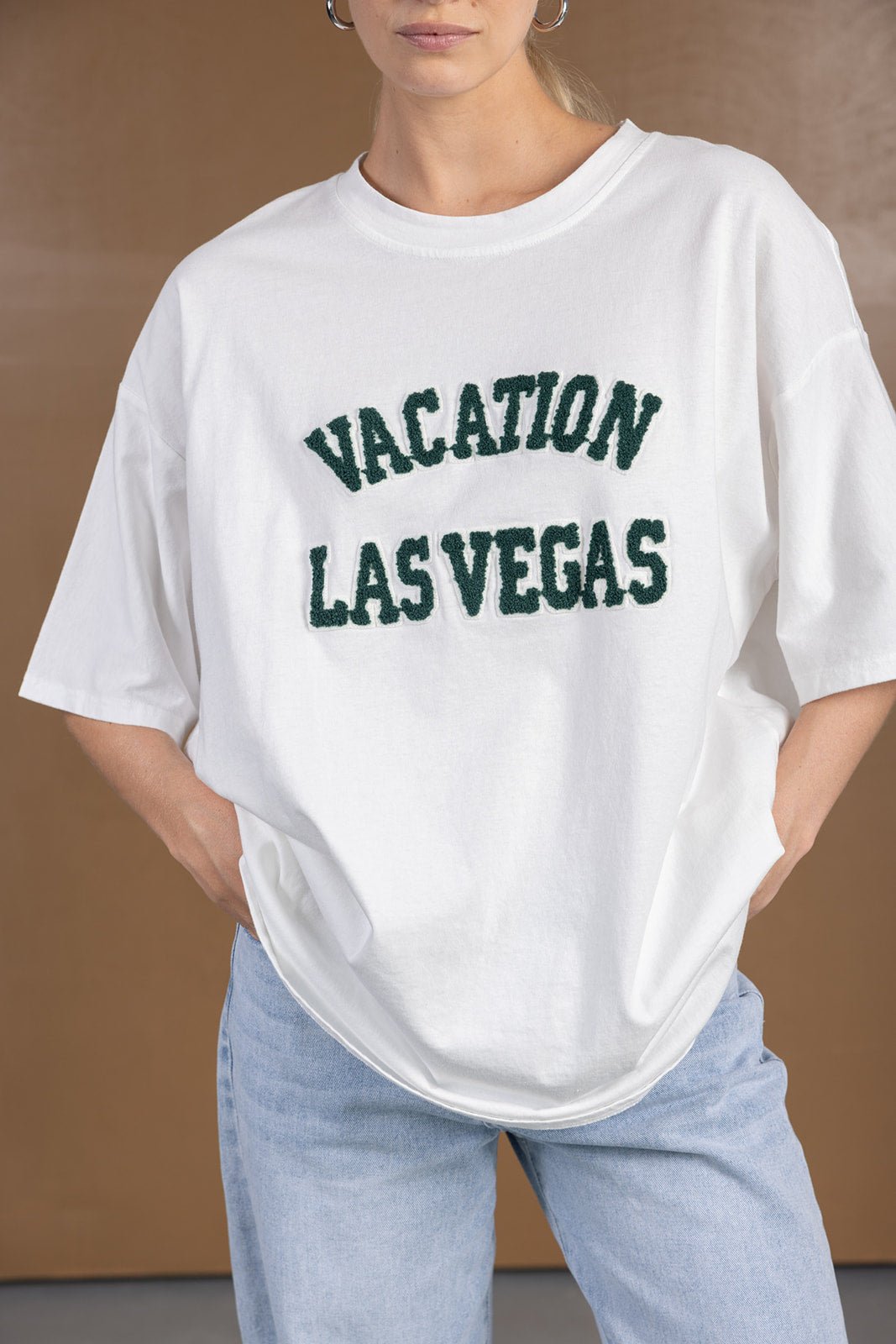 חולצת טי לבנה לנשים עם כיתוב ירוק VACATION LAS VEGAS, גזרה רחבה, ג'ינס בהיר