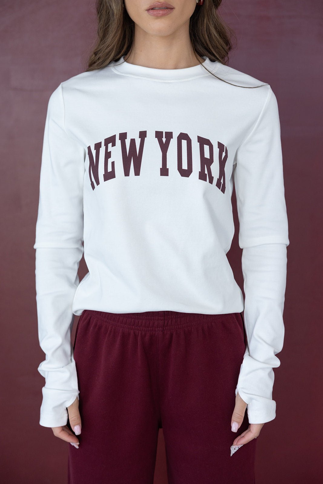 חולצת טריקו לבנה עם כיתוב NEW YORK לנשים, בשילוב מכנסי טרנינג בורדו אופנתיים