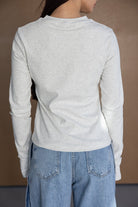 חולצת שרוול ארוך אפורה לנשים עם ג'ינס תכלת, צילום גב, בגדי אופנה לנערות