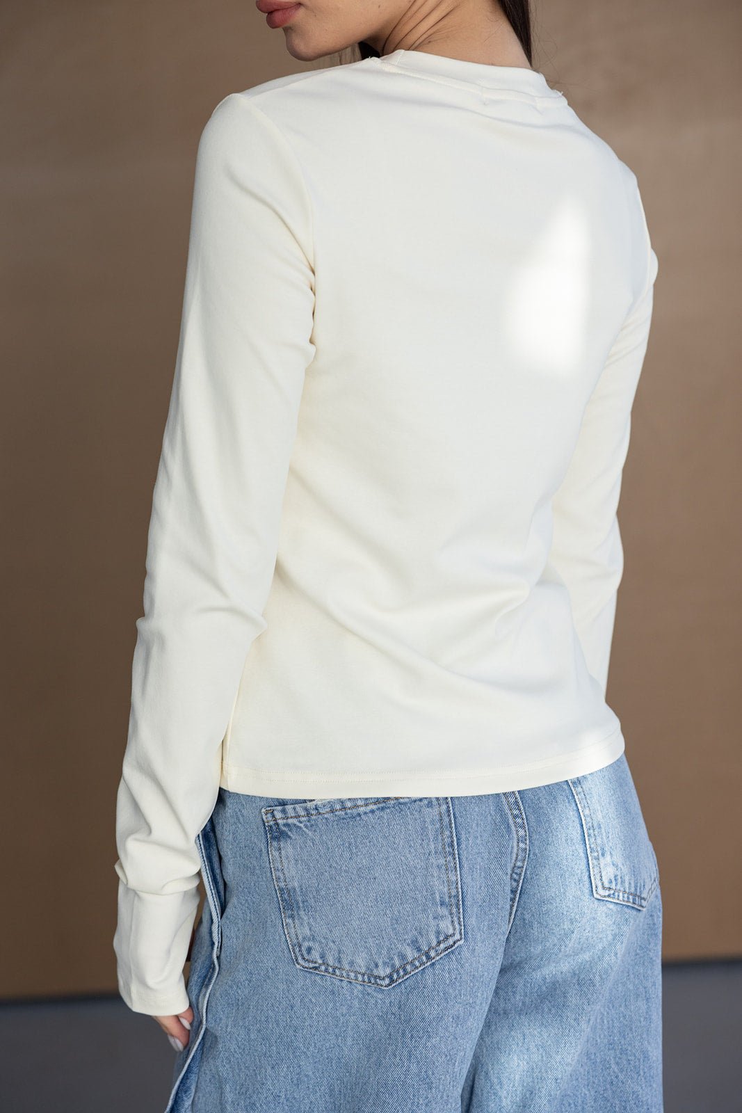 חולצת שרוול ארוך לבנה לנשים עם ג'ינס כחול בהיר, מראה קז'ואל אופנתי