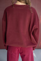 אישה לובשת סווטשירט בצבע בורדו ומכנסיים תואמים, אופנת נשים ונערות