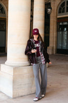 אופנת רחוב לנשים, דוגמנית עם כובע בייסבול, ז'קט עור, מכנסי ספורט אפורים ומגפי סניקרס