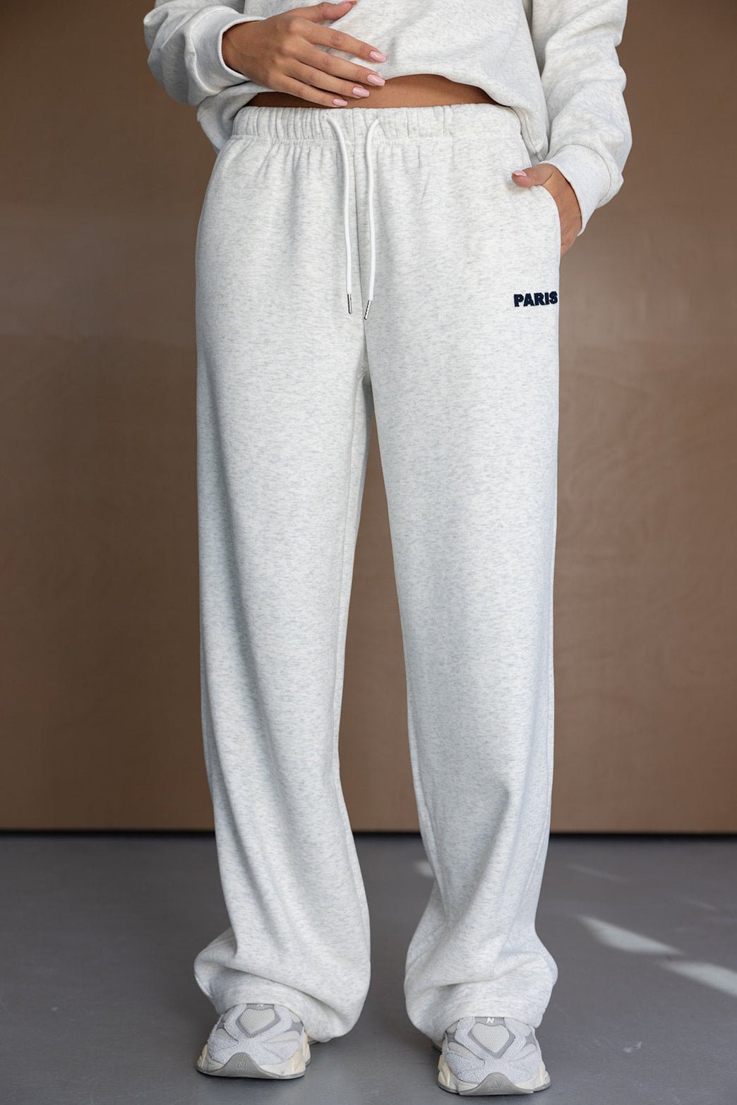 מכנסי טרנינג נשים בגזרה רחבה בצבע אפור בהיר, כיתוב PARIS, לוק קז'ואל אופנתי