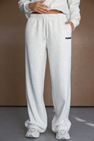 מכנסי טרנינג נשים בגזרה רחבה בצבע אפור בהיר, כיתוב PARIS, לוק קז'ואל אופנתי