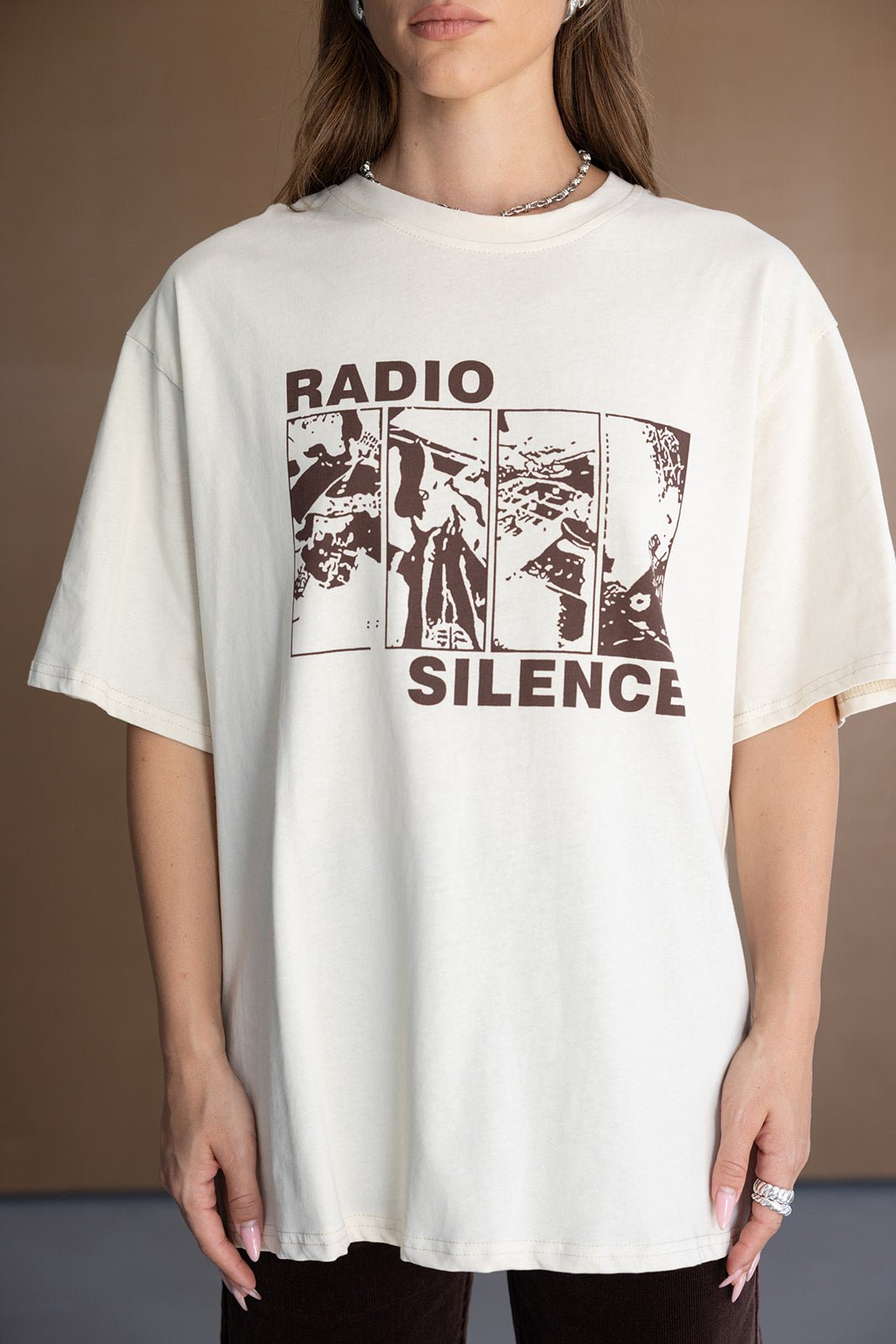 אישה לובשת חולצת טי שירט אופנתית בהדפס RADIO SILENCE בגוון אוף וייט, טרנדי לנשים