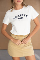 דוגמנית עם חולצת טי שירט לבנה עם כיתוב ומיני חצאית בז', אופנת נשים קיץ