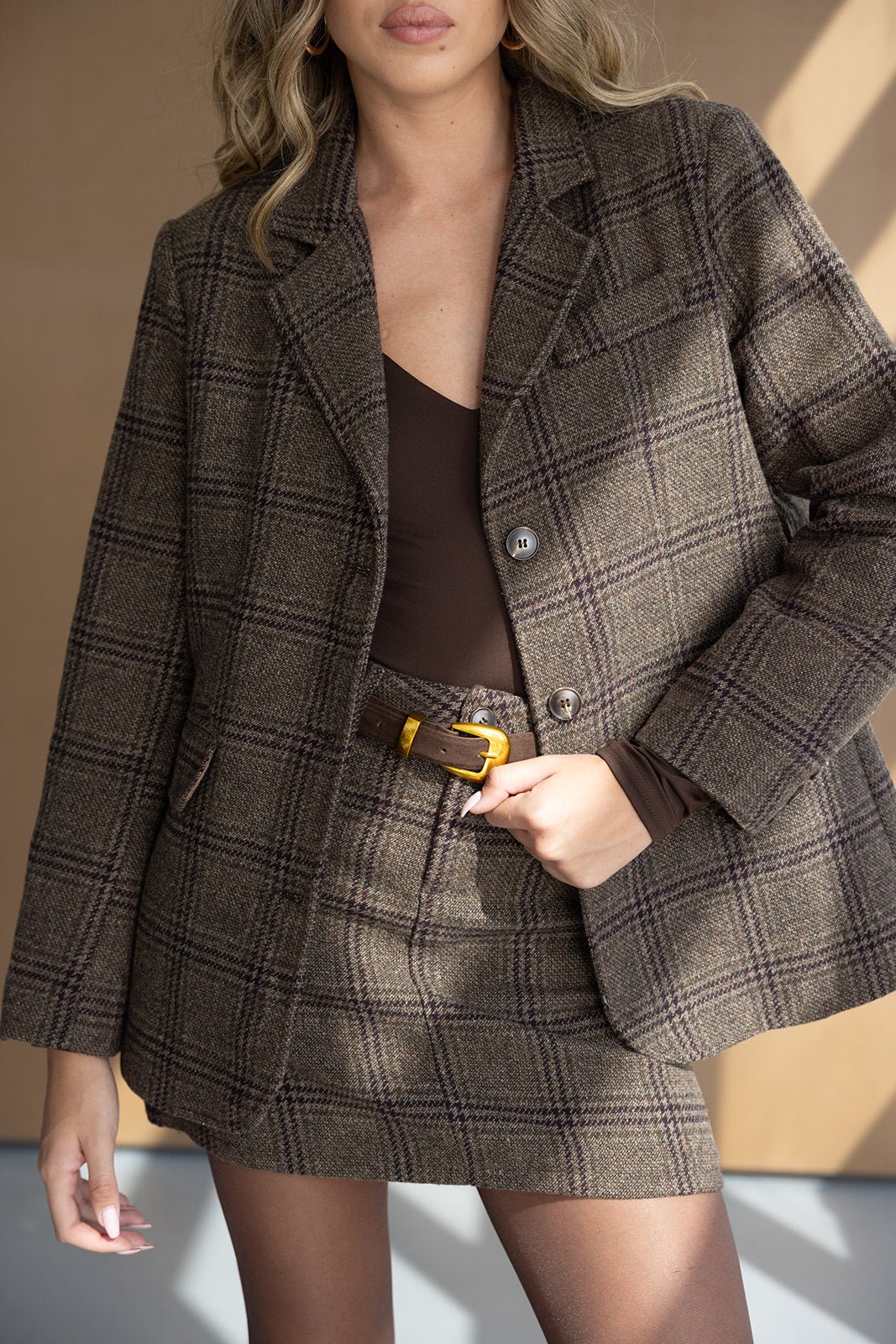 חליפת נשים חצאית וז'קט בד משובץ חום, חולצת גוף חומה, לוק אופנתי לחורף