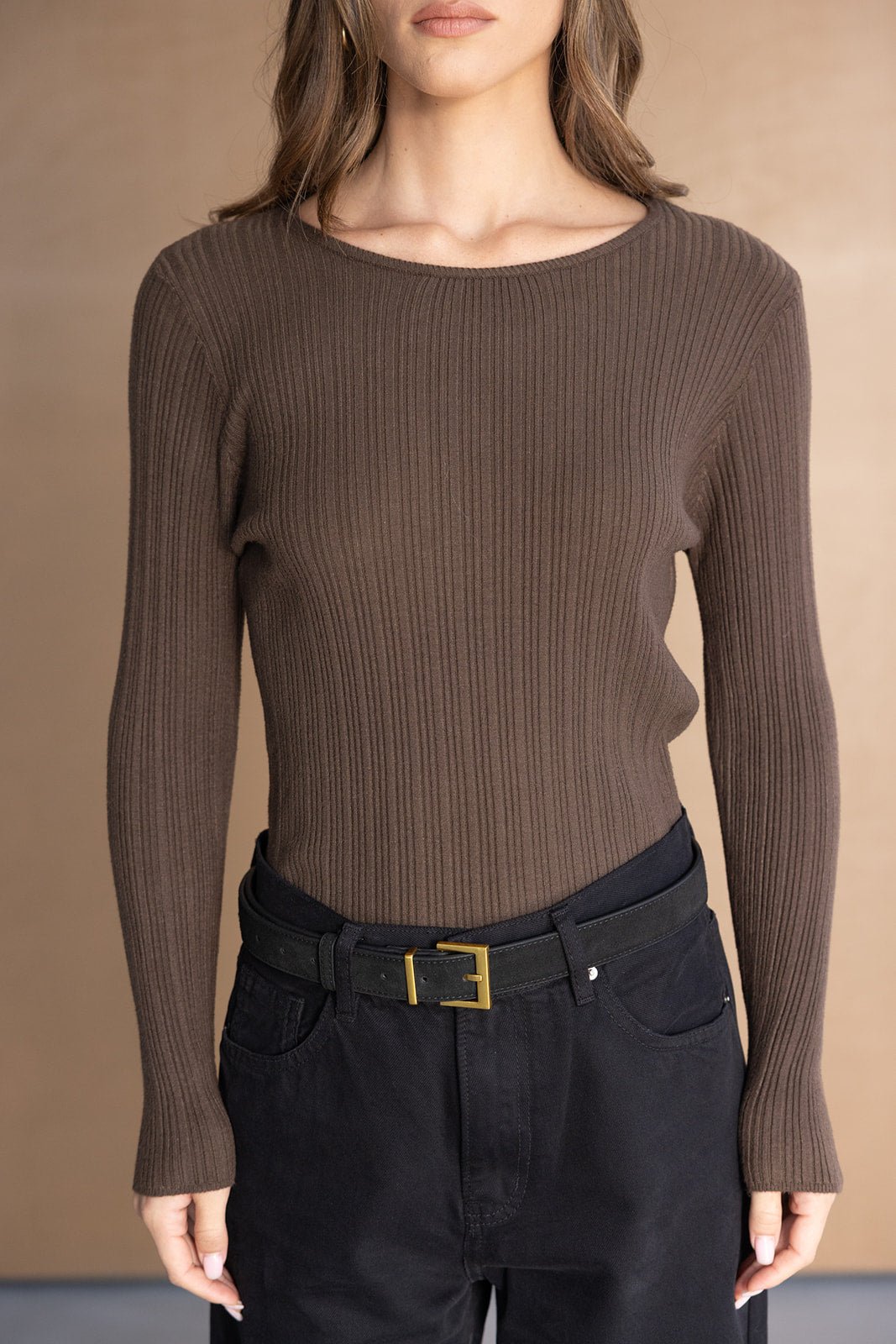 חולצת סריג חומה ארוכה עם צלעות, מכנסיים שחורים חגורת אבזם זהב, אופנת נשים צעירה