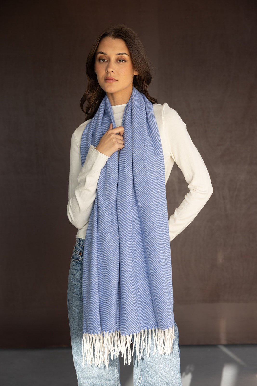 צעירה לובשת צעיף נשים כחול עם פרנזים, חולצה לבנה וג׳ינס, סטייל אופנה עכשווית