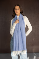 צעירה לובשת צעיף נשים כחול עם פרנזים, חולצה לבנה וג׳ינס, סטייל אופנה עכשווית