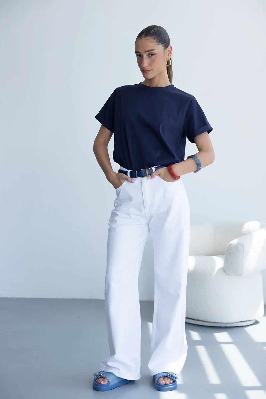 אישה עם חולצת טי שירט כחולה, מכנסיים לבנים רחבים וסנדלי פלטפורמה כחולים, אופנת קיץ לנשים