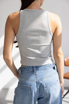 אישה עם גופיית ספורט אפורה במראה קז'ואל ומכנסי ג'ינס רחבים, טרנד אופנה עכשווי לנשים