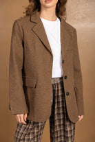 בלייזר חום לנשים עם כפתורים שחורים, חולצה לבנה ומכנס משובץ חום, מראה אלגנטי וטרנדי