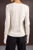 חולצת נשים ארוכה בצבע שמנת ומכנסי ג'ינס שחורים, צילום מגב