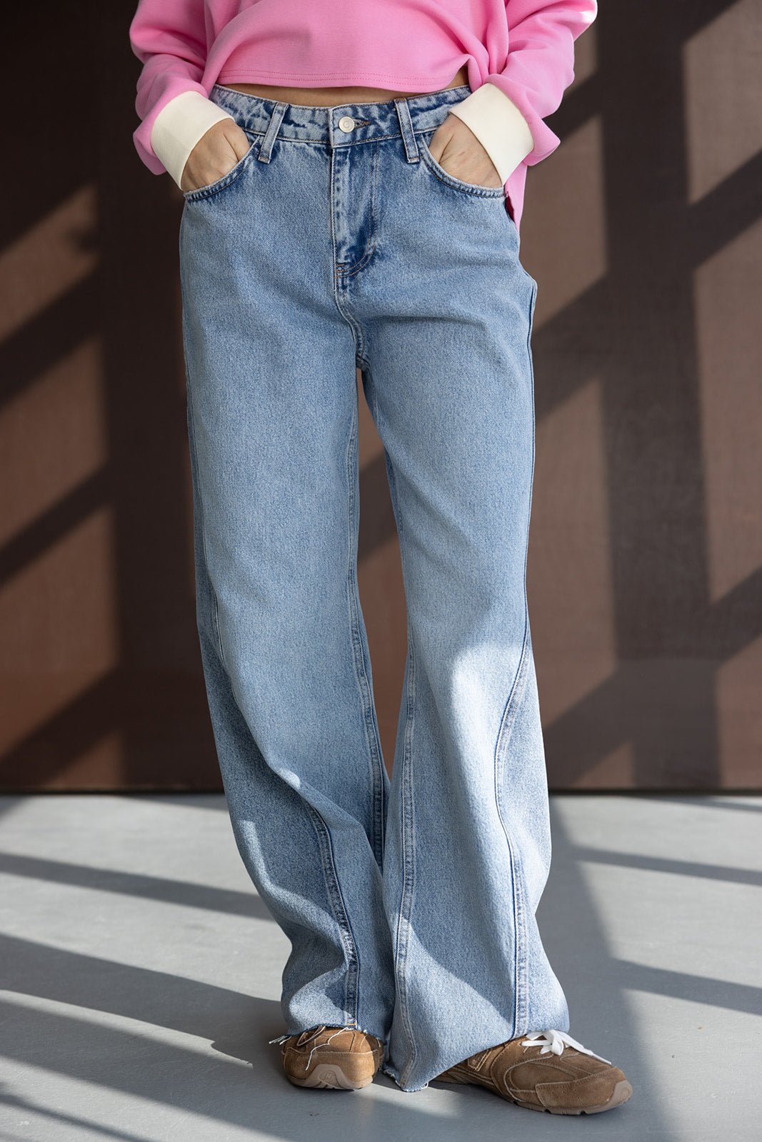 ג'ינס נשים בגזרה רחבה, דנים תכלת, עם סווטשרט ורוד ונעלי סניקרס חומות