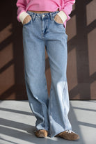 ג'ינס נשים בגזרה רחבה, דנים תכלת, עם סווטשרט ורוד ונעלי סניקרס חומות