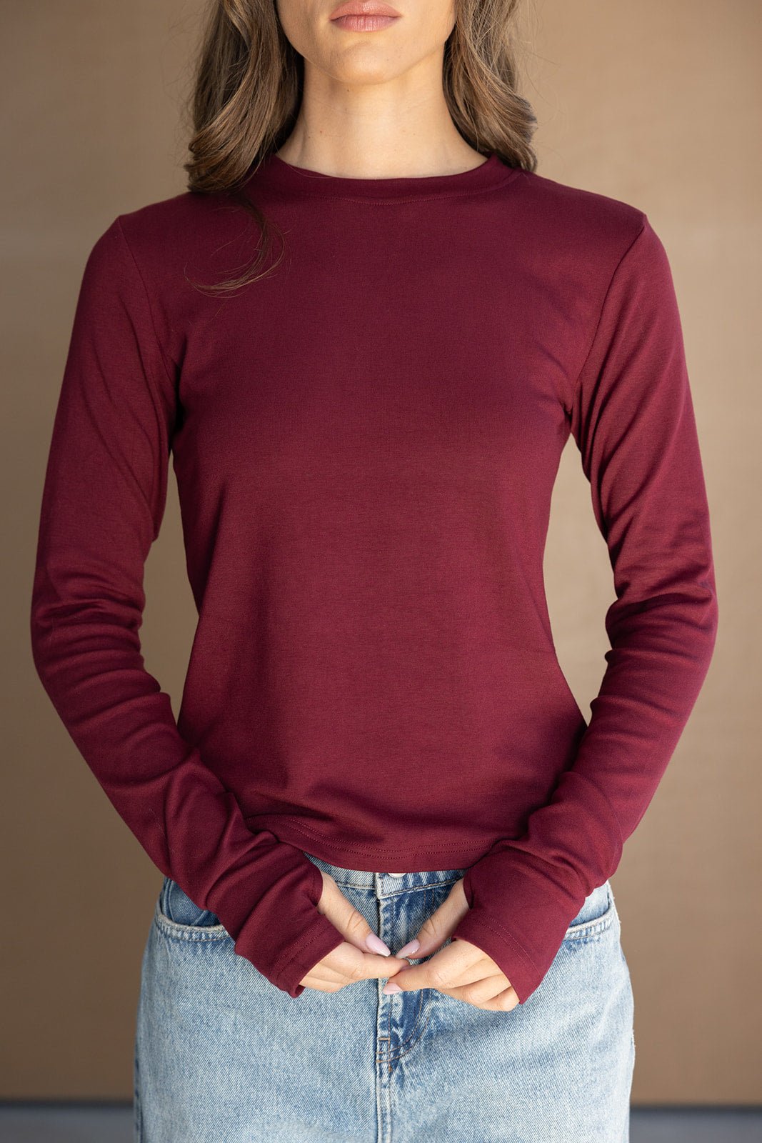 חולצת נשים בורדו שרוול ארוך מבד חלק עם צווארון עגול, בשילוב ג'ינס בהיר