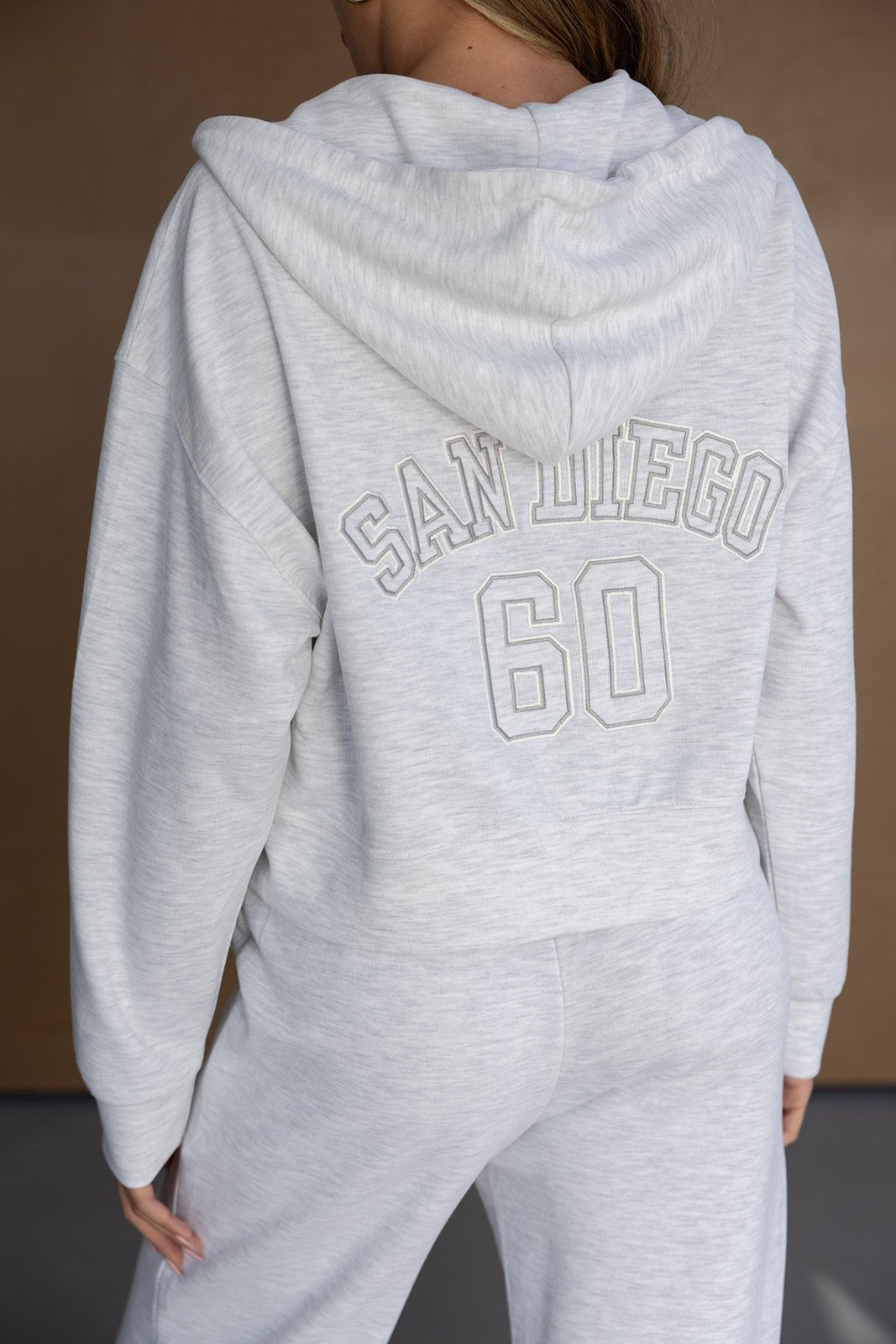 סט טרנינג נשים אפור עם קפוצ׳ון, כיתוב SAN DIEGO 60 בגב, אופנה נוחה ויומיומית