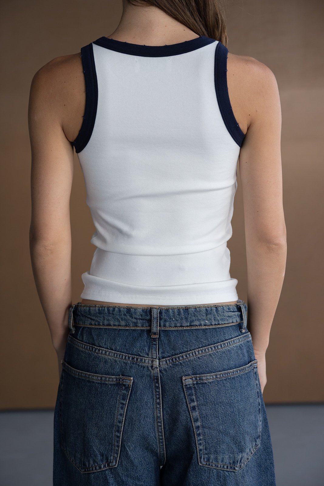 גופיית נשים לבנה עם שוליים כחולים ומכנסי ג'ינס, אופנת קיץ לנערות