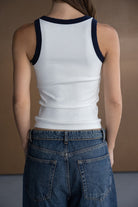 גופיית נשים לבנה עם שוליים כחולים ומכנסי ג'ינס, אופנת קיץ לנערות