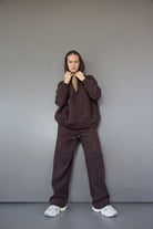 אישה עם קפוצ'ון וחולצה כהה רחבה ומכנסיים תואמים, לוק לבוש אופנתי לנשים