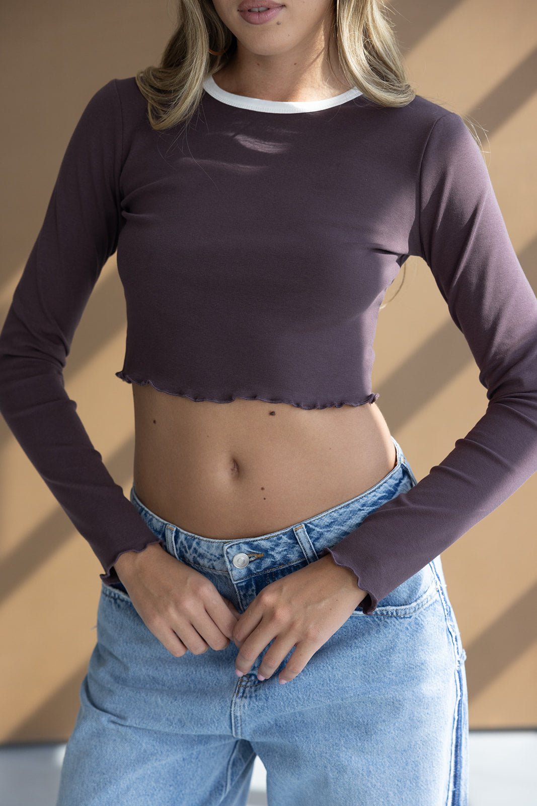 טי שירט קרופ סגולה ארוכה עם מכפלת גלית, צווארון לבן וג'ינס בהיר לנשים