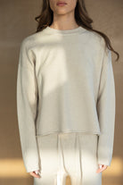 דוגמנית לובשת סט טרנינג נשים בצבע בז', חולצת שרוולים ארוכים ומכנסיים עם שרוך