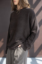 דוגמנית עם סוודר חום רחב ומכנסיים משובצים אופנתיים לאישה, צילום אופנה עדכני