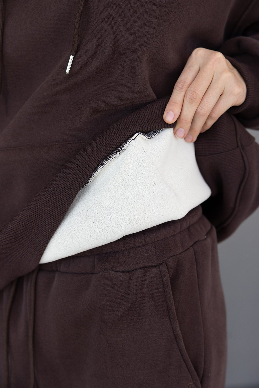 סווטשירט חום לנשים עם בד פנימי פליז לבן, תקריב על מרקם הבד והשרוול