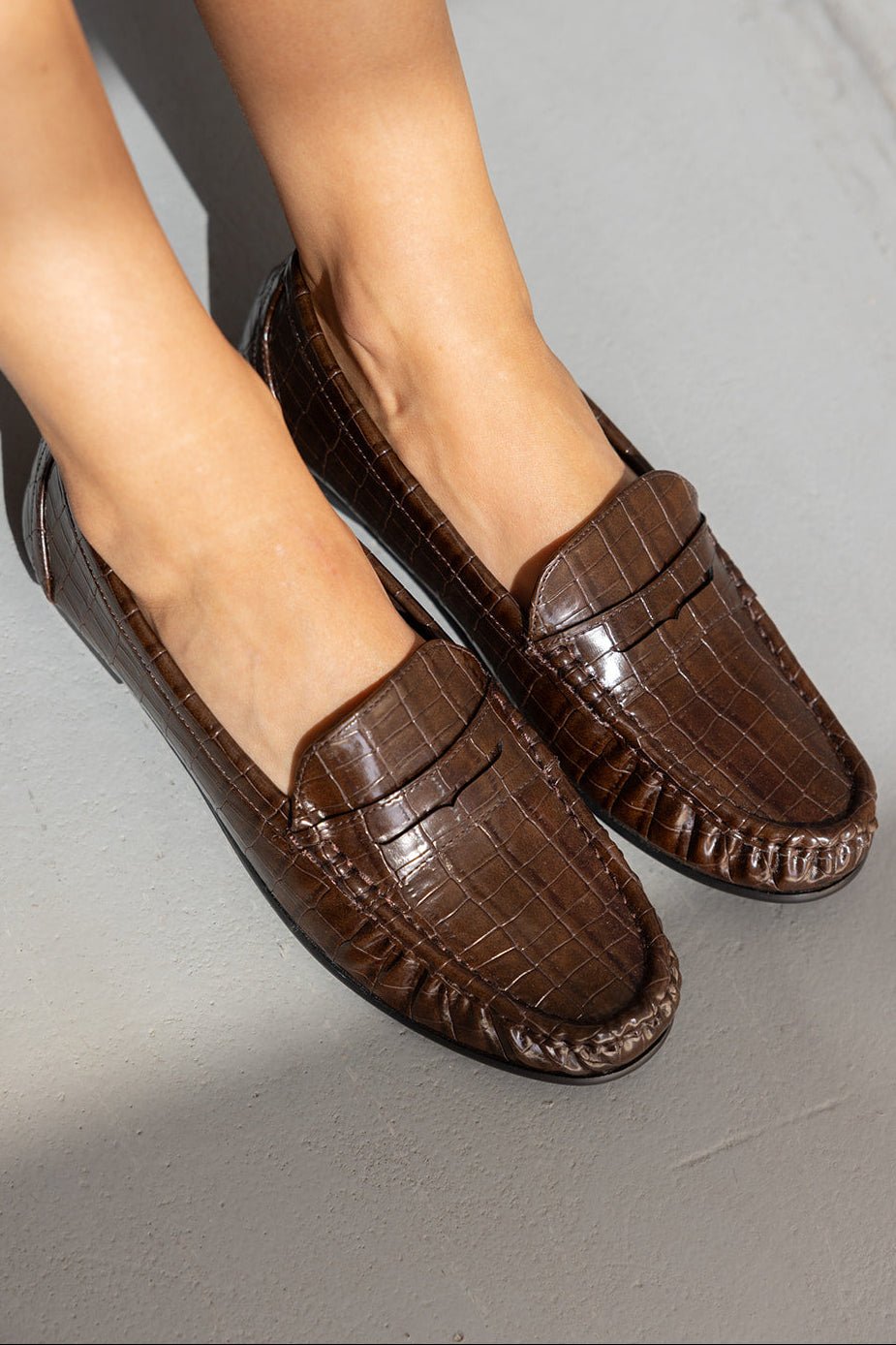 נעלי מוקסין נשים חום דמוי עור תנין, סגנון אופנתי על רקע אפור