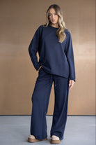 דוגמנית לובשת סט טרנינג נשים כחול כהה עם מכנס רחב וסווטשרט, אופנה עדכנית לנשים