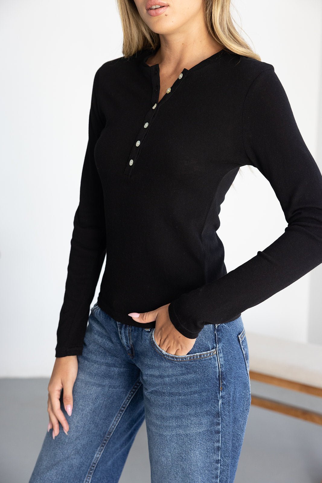 חולצת נשים שחורה עם שרוול ארוך וכפתורים, משולבת עם ג'ינס קז'ואל אופנתי