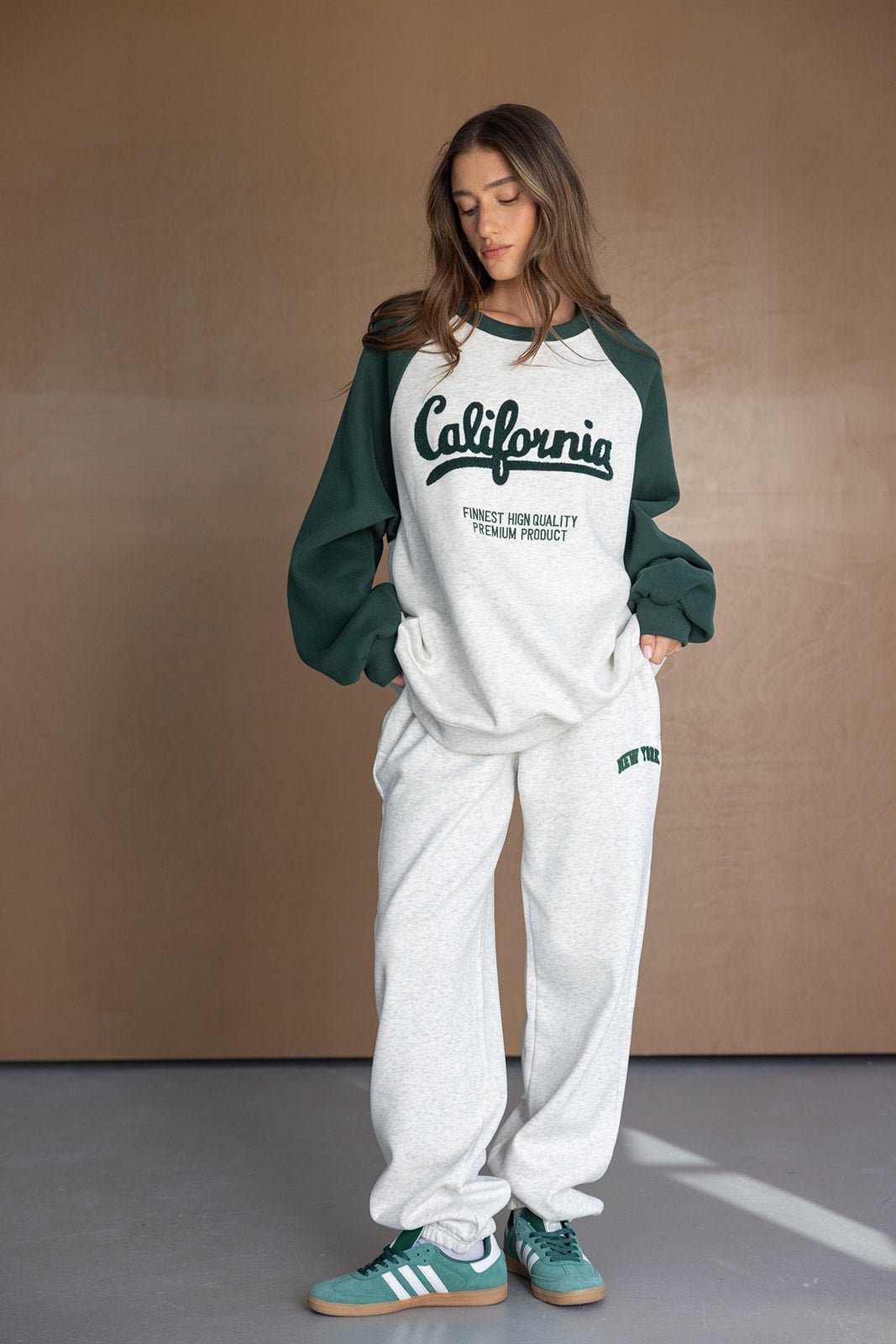 דוגמנית לובשת סט טרנינג אופנתי בצבעי ירוק ולבן עם כיתוב 'California', מושלם לאופנת רחוב לנשים