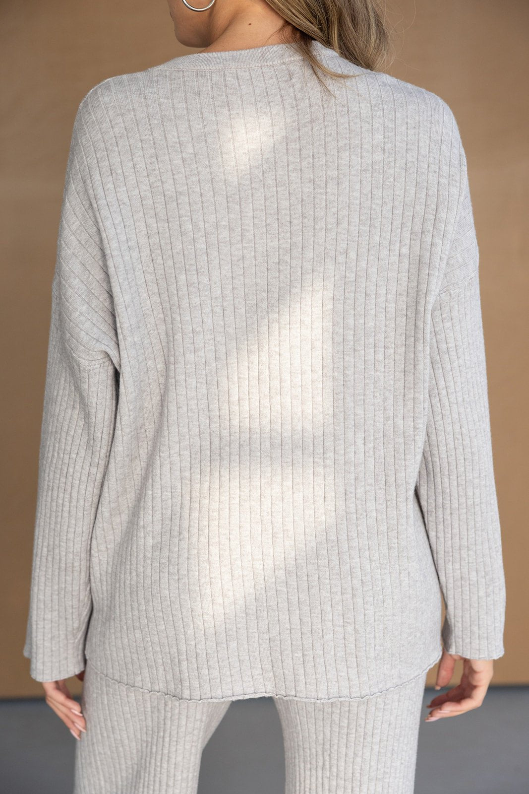 אישה עם חולצת סט פסים אפורה ובד סריג נעים, בגדי נשים אופנתיים לחורף