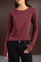 חולצת נשים ארוכה בצבע בורדו בשילוב מכנסי ג'ינס שחורים, אופנת סתיו לנערות