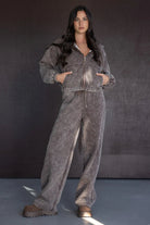 דוגמנית לובשת סט טרנינג אופנתי לנשים בצבע אפור, בגזרת אוברסייז, רקע סטודיו