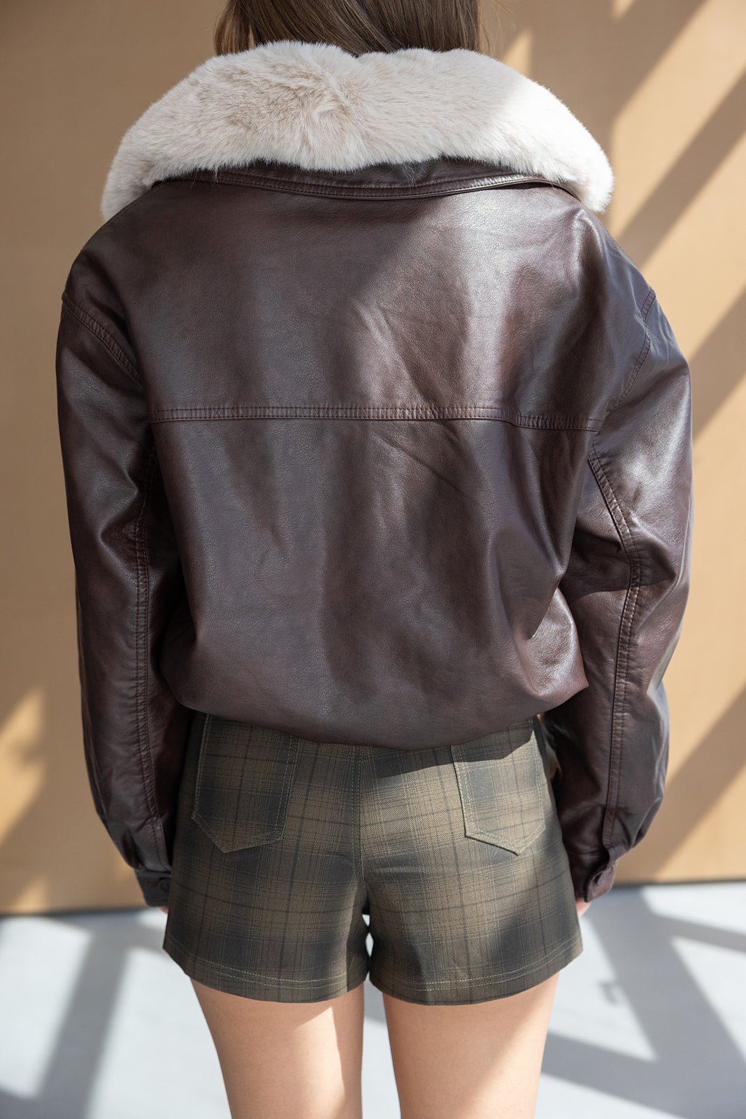 מעיל עור חום עם צווארון פרווה לבן, בשילוב שורטס משובץ לנשים