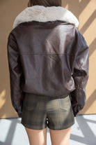 מעיל עור חום עם צווארון פרווה לבן, בשילוב שורטס משובץ לנשים